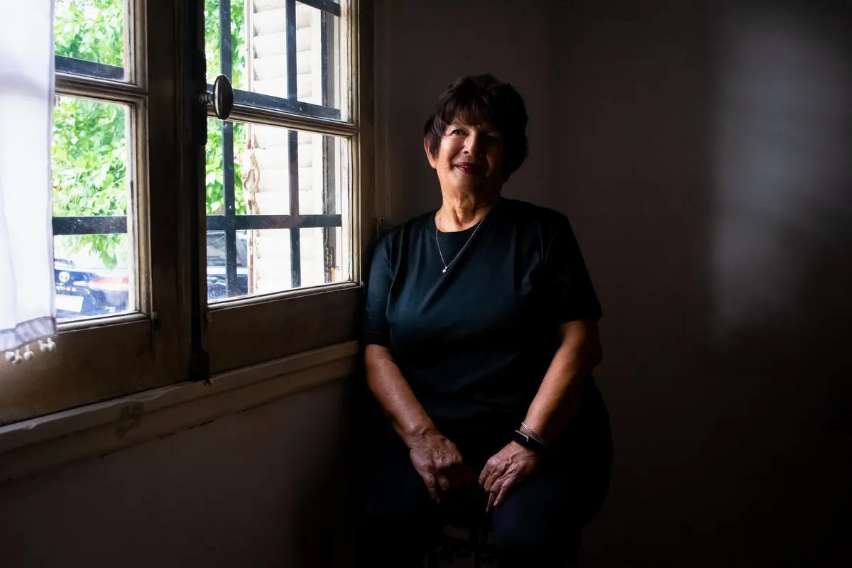 Femme âgée assise près d'une fenêtre baignée de lumière naturelle